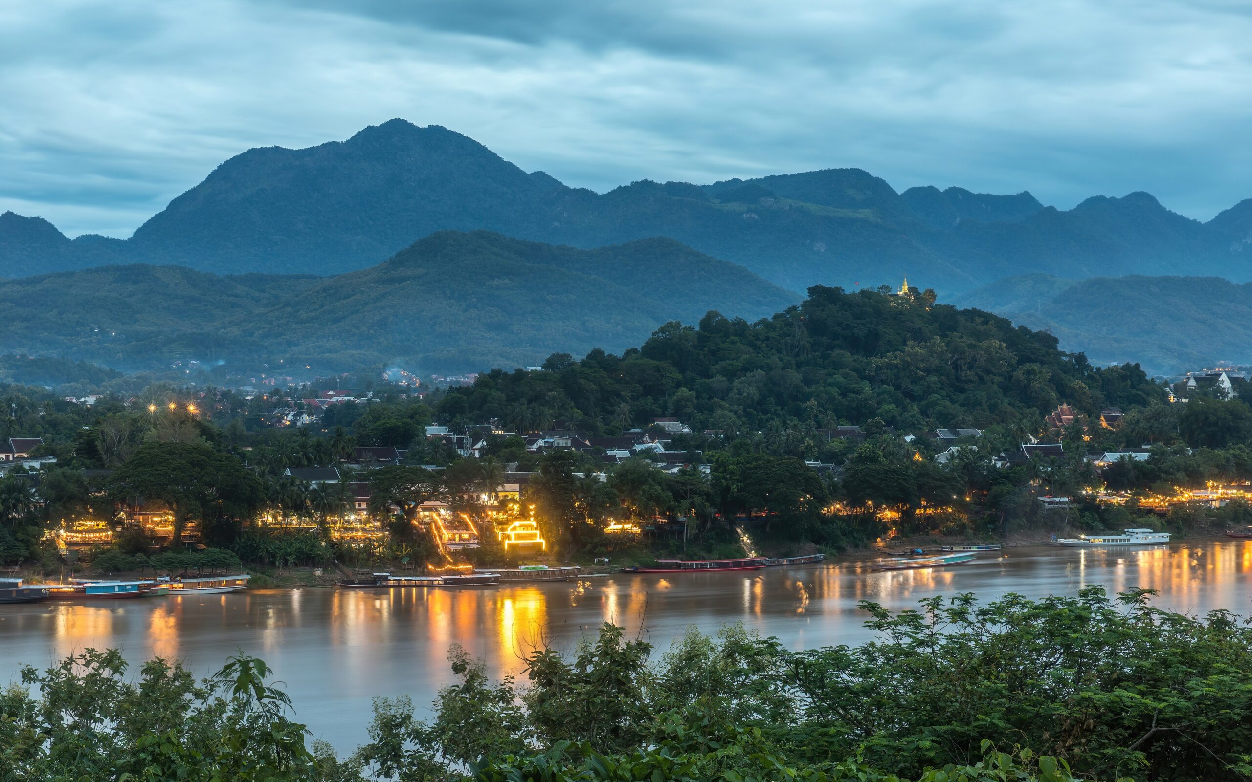 Mount Phou Si and lights reflected on the Mekong at sunset in Luang Prabang