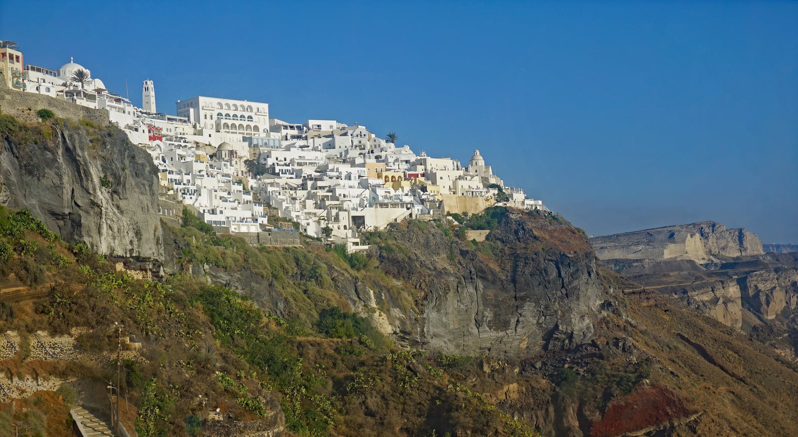 White buildings of Fira rising above Santorini’s caldera cliffs