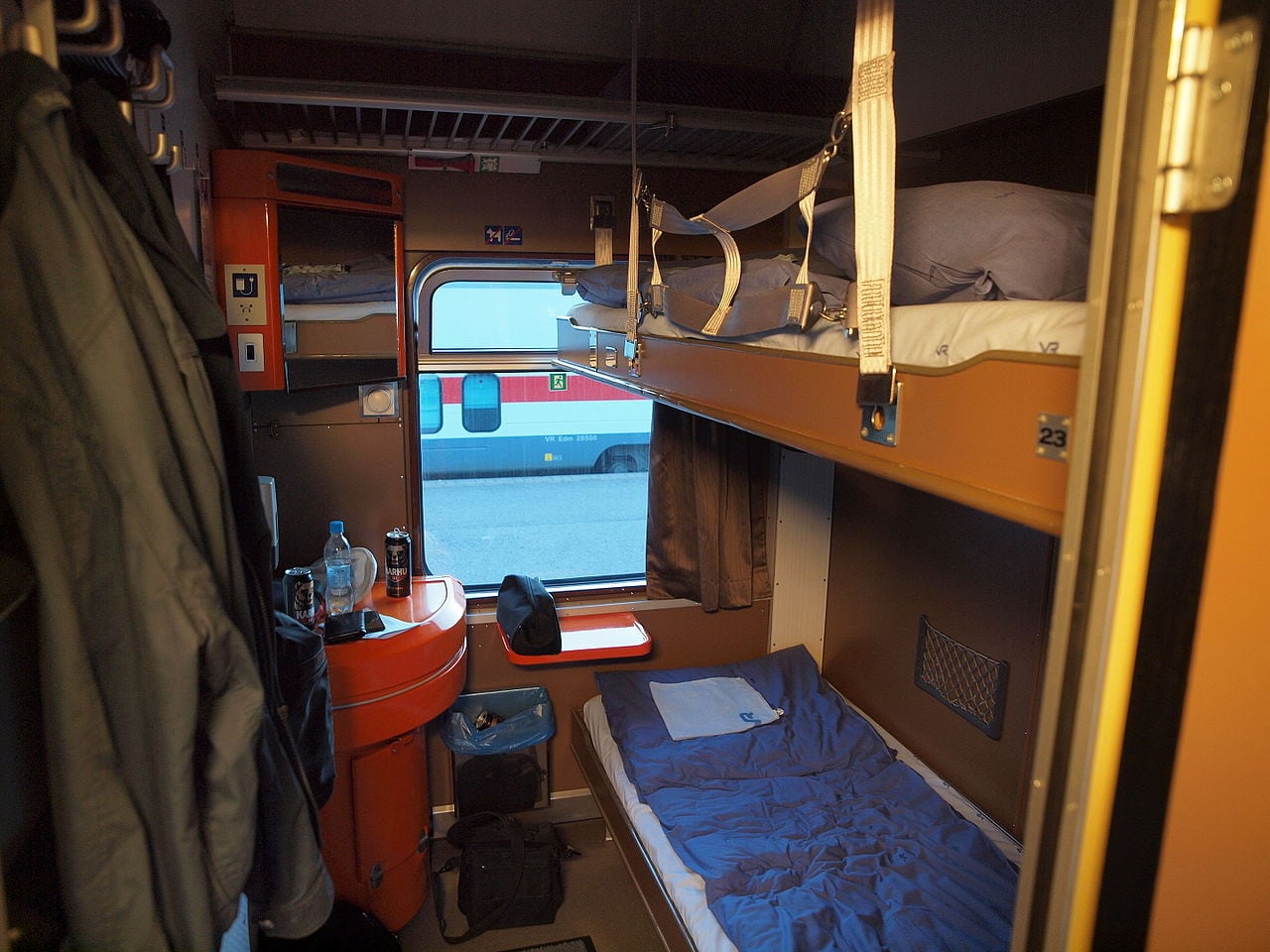Two made-up berths and luggage storage inside a Finnish overnight train sleeping cabin