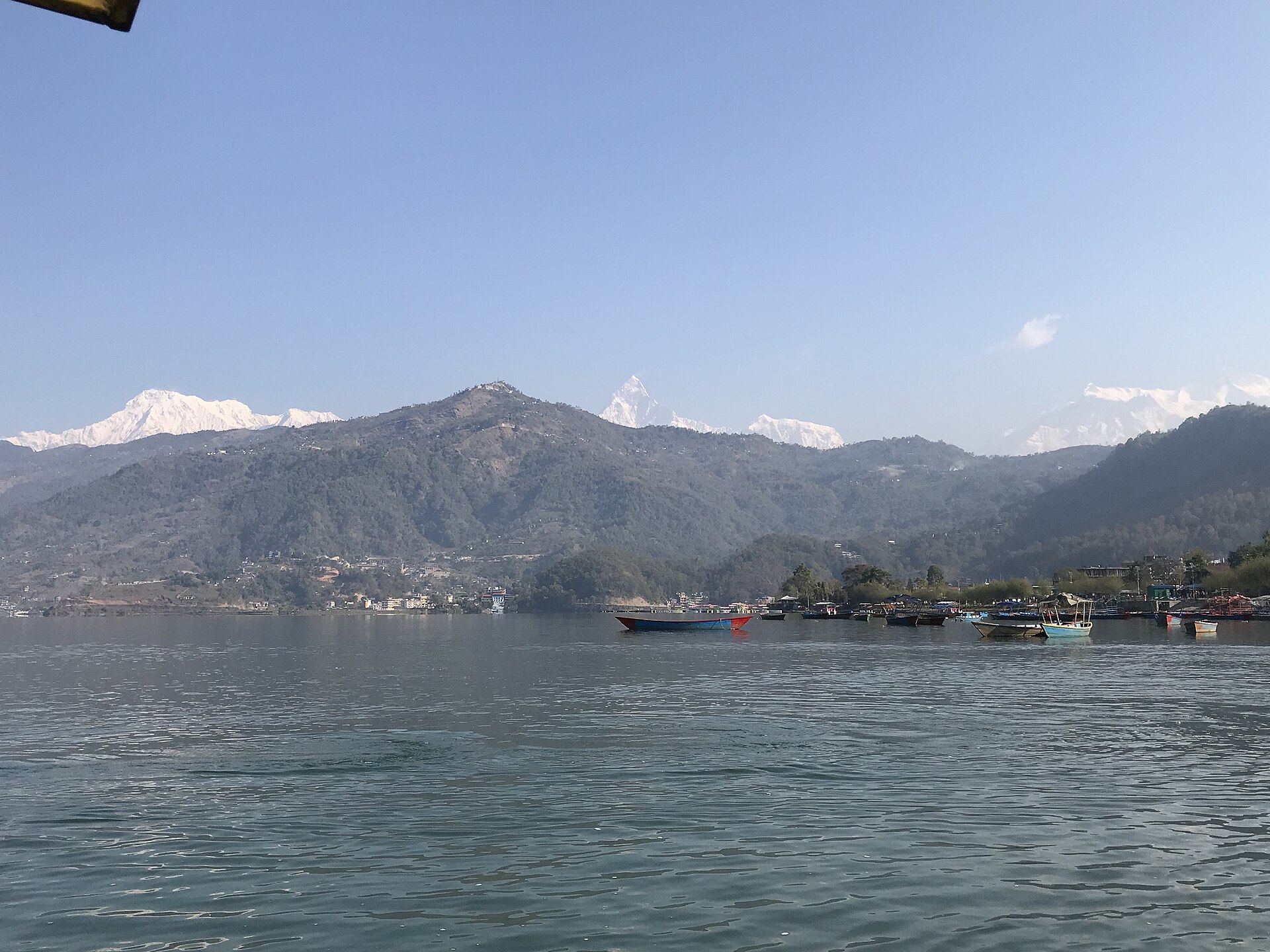 Boats on Phewa Lake with the Annapurna range rising beyond Pokhara, Nepal