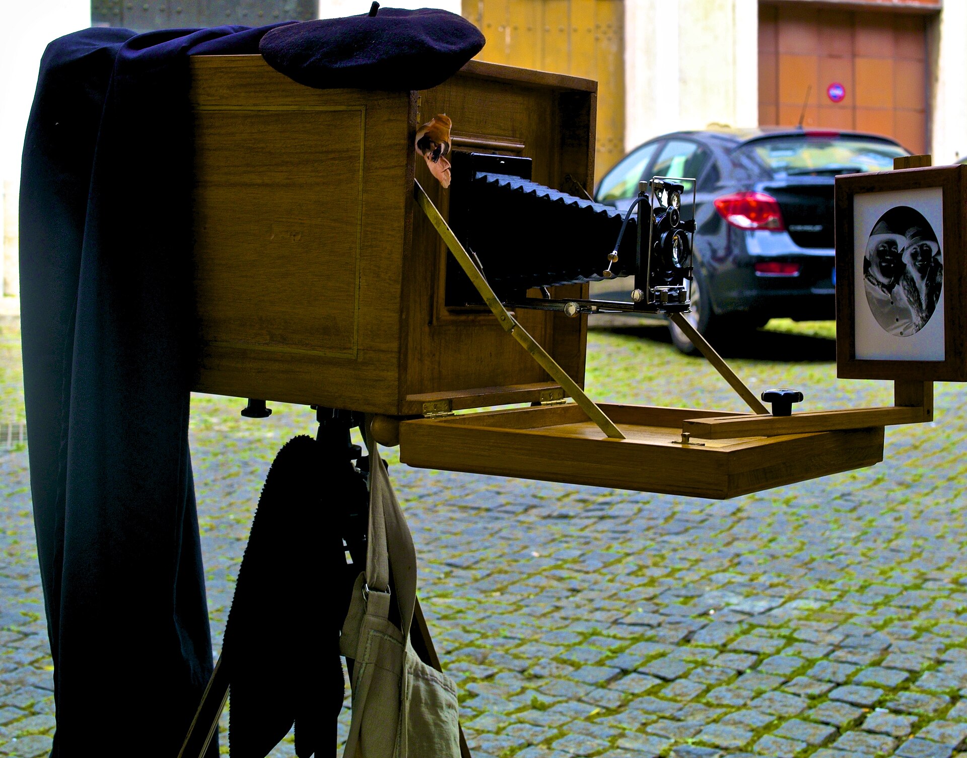 Street photographer carrying camera equipment in Alfama, Lisbon