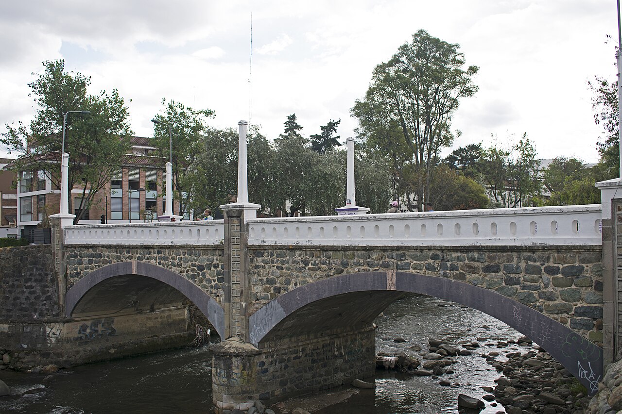 Stone arches of Puente Mariano Moreno spanning the Tomebamba River in Cuenca