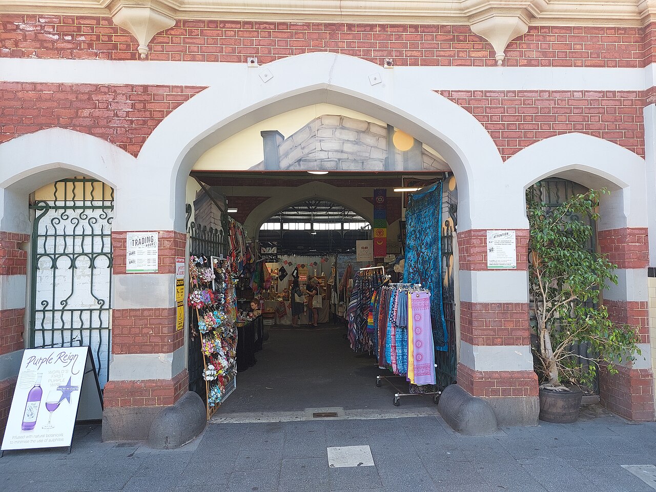 Arched brick-and-stone entrance to Fremantle Markets from South Terrace, with stalls visible inside.