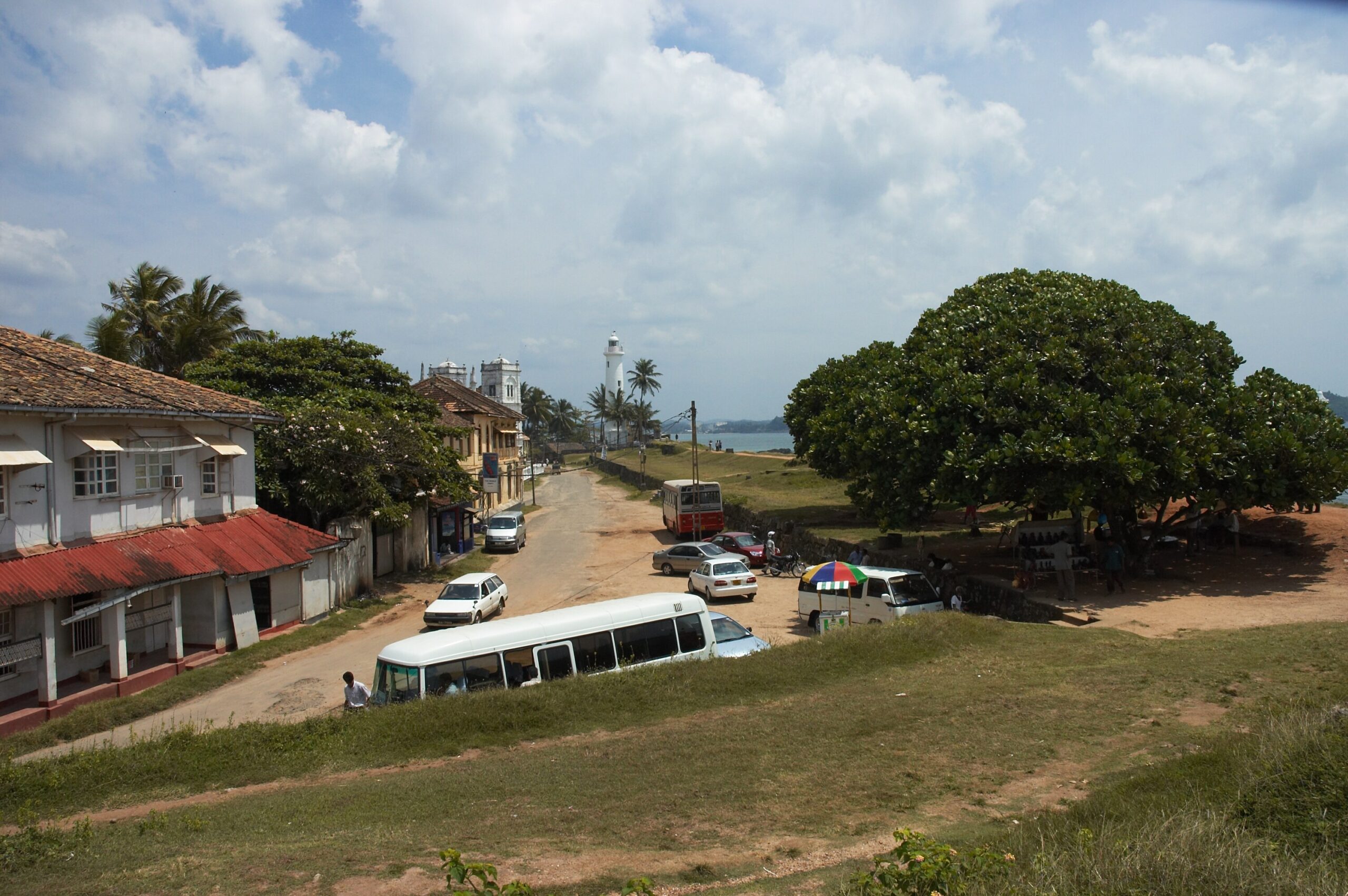 Galle Fort streets and buildings beside the ramparts, with the white lighthouse in the distance.