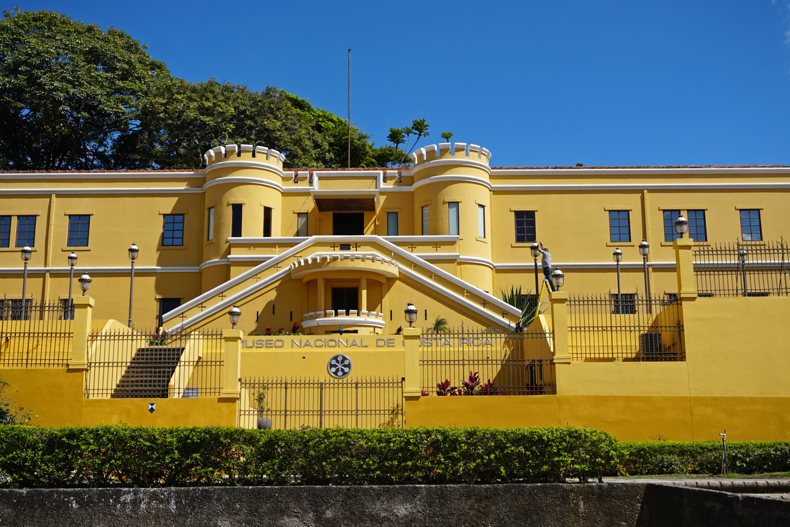 Yellow west façade and twin stairways of Costa Rica's National Museum in San José.