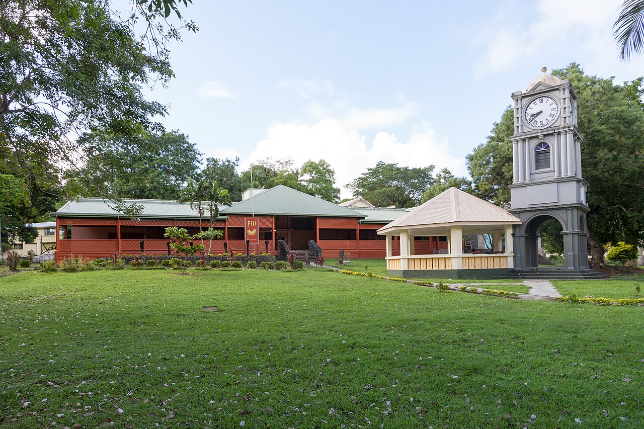 Fiji Museum building and a clock tower beside a pavilion in Suva's leafy Thurston Gardens.