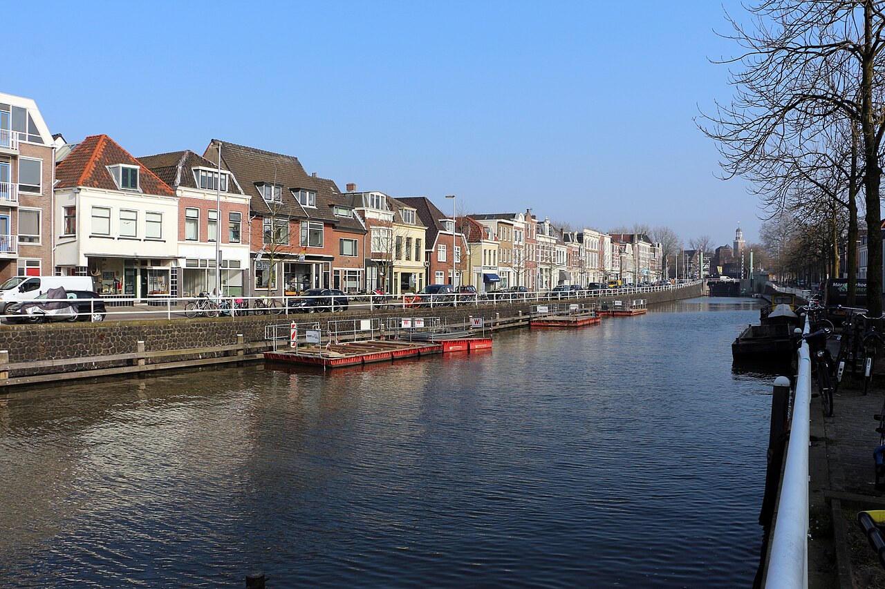 Buildings and street-level railings beside Utrecht’s Oudegracht, with work platforms along the canal wall.